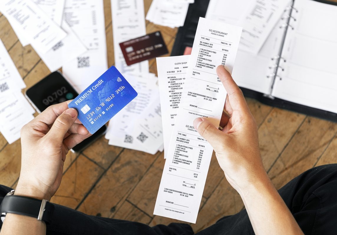 Person holding receipts and credit card
